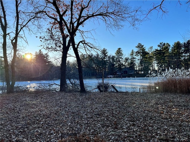 yard at dusk featuring a water view