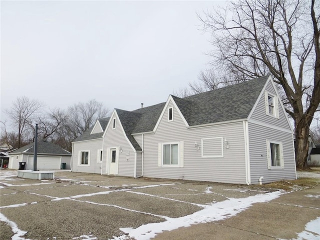 exterior space with central air condition unit, an outdoor structure, and a garage