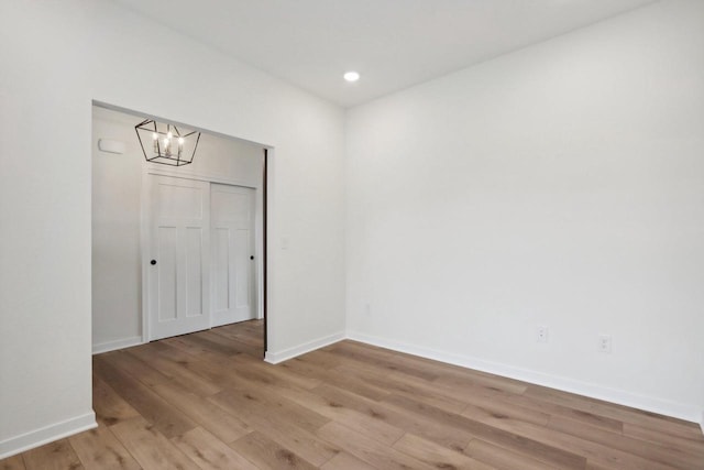 unfurnished room featuring light hardwood / wood-style flooring and a notable chandelier