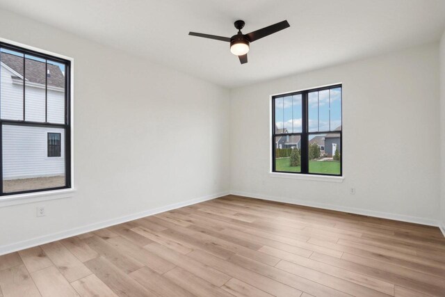 unfurnished room featuring ceiling fan, light wood-type flooring, and a wealth of natural light