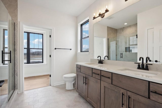 bathroom featuring tile patterned flooring, plenty of natural light, toilet, and vanity