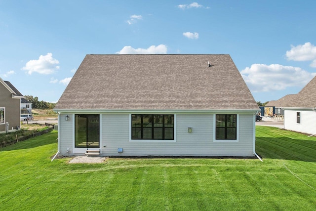 rear view of property featuring a lawn