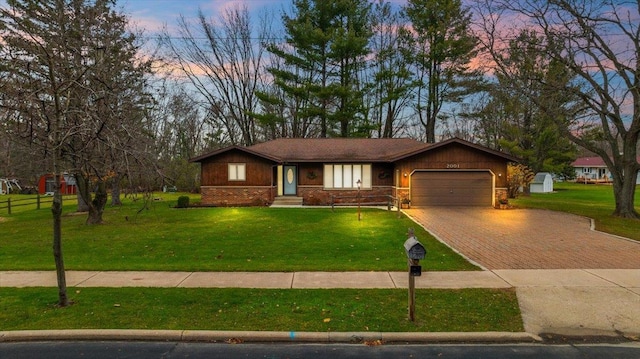 ranch-style house with a yard and a garage