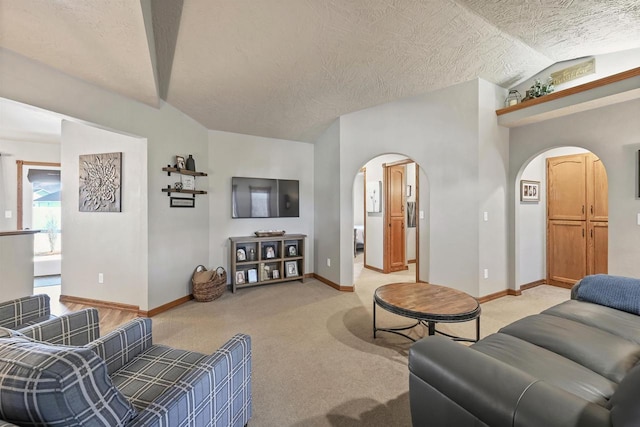 carpeted living room featuring a textured ceiling and lofted ceiling