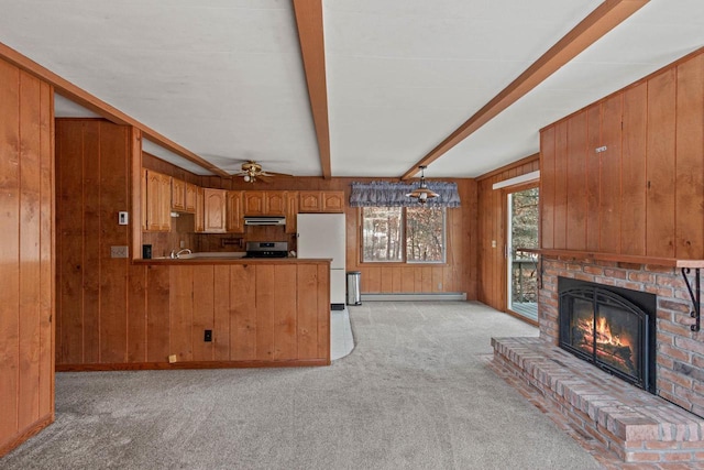 kitchen with wood walls, stove, light carpet, ceiling fan, and decorative light fixtures