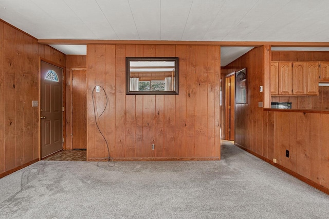 entryway with wood walls and light colored carpet