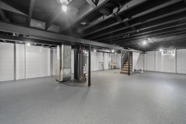 basement featuring sink, heating unit, and water heater