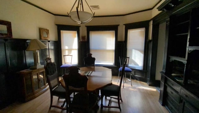 dining area with light wood-type flooring and crown molding