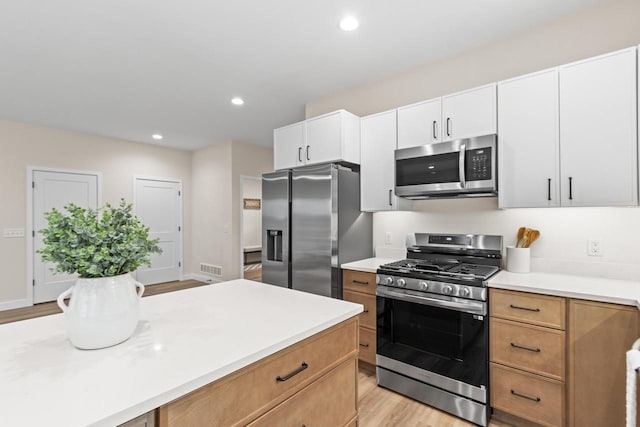 kitchen featuring white cabinetry, appliances with stainless steel finishes, and light hardwood / wood-style flooring