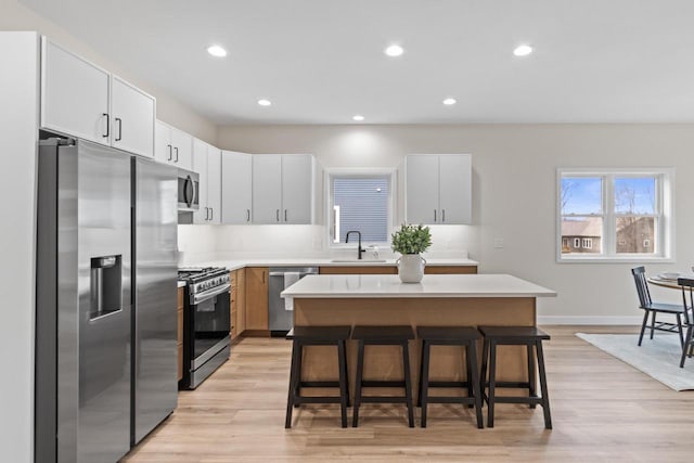 kitchen featuring white cabinetry, a center island, sink, and appliances with stainless steel finishes