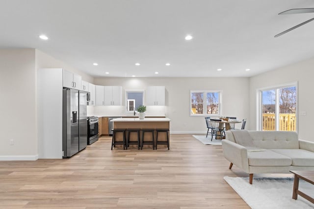 living room featuring ceiling fan and light wood-type flooring