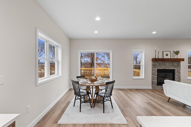 dining room featuring a fireplace and light hardwood / wood-style flooring