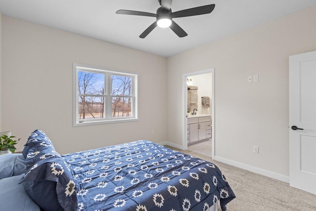 bedroom featuring ensuite bathroom, ceiling fan, sink, and light carpet