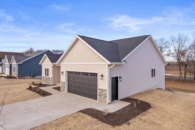 view of front of property featuring central air condition unit and a garage