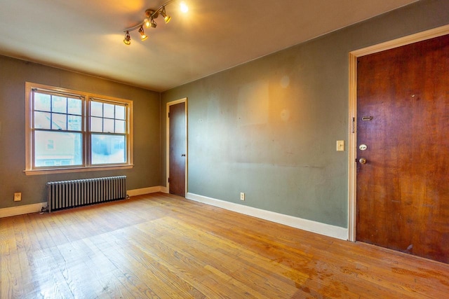 spare room with light hardwood / wood-style floors and radiator