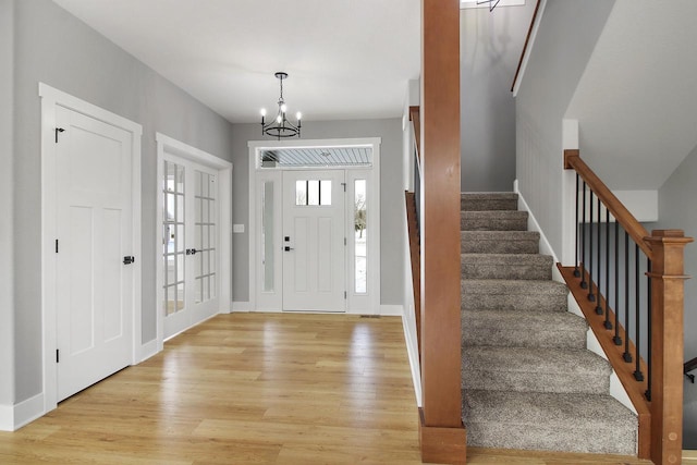 foyer with light wood-type flooring and a chandelier