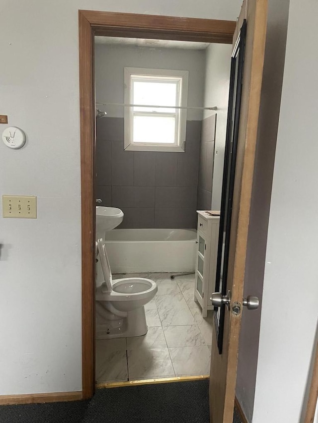 bathroom with toilet and tiled shower / bath