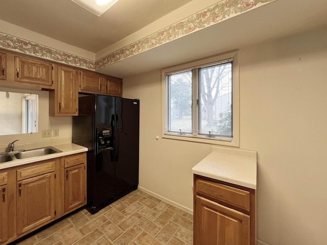 kitchen with black fridge with ice dispenser and sink