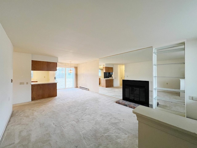 unfurnished living room with a baseboard radiator, a notable chandelier, and light colored carpet