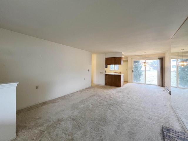 unfurnished living room with light carpet and a chandelier