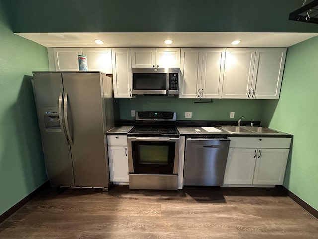 kitchen with white cabinets, dark hardwood / wood-style floors, sink, and appliances with stainless steel finishes