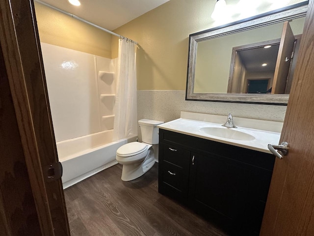 full bathroom featuring hardwood / wood-style floors, vanity, toilet, and shower / tub combo