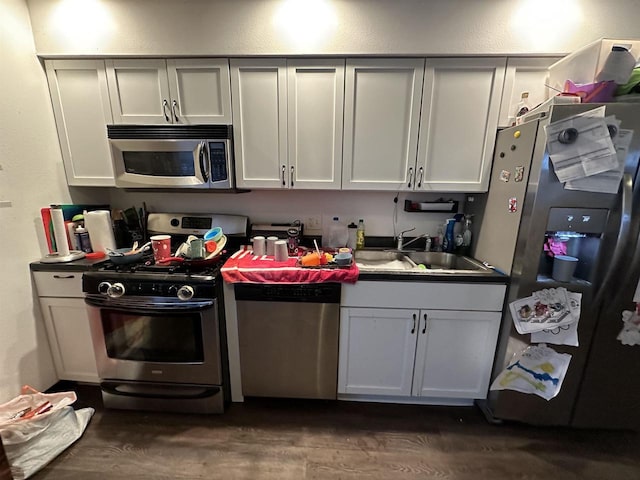 kitchen with white cabinets, dark hardwood / wood-style floors, sink, and appliances with stainless steel finishes