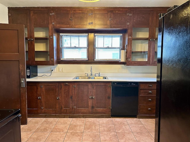 kitchen with sink, light tile patterned flooring, and black appliances