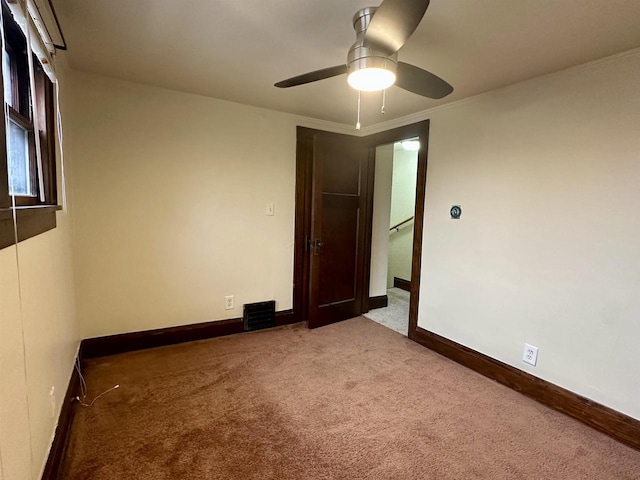 carpeted spare room with ceiling fan and crown molding