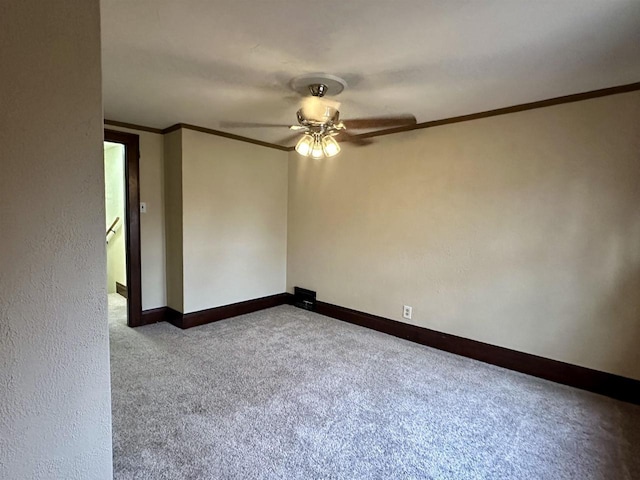 unfurnished room with ceiling fan, light colored carpet, and ornamental molding