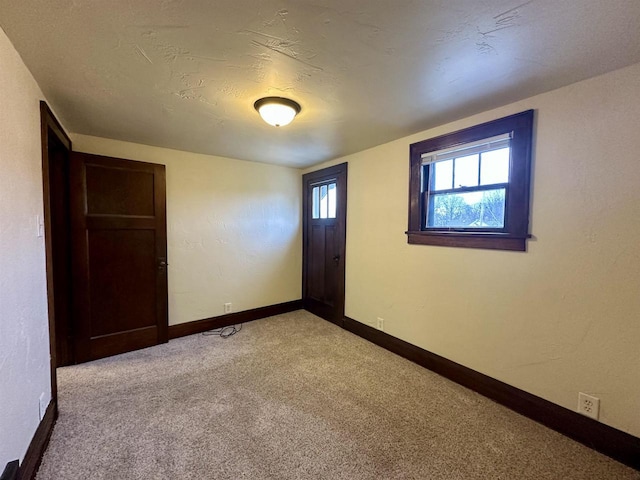 carpeted empty room with a textured ceiling