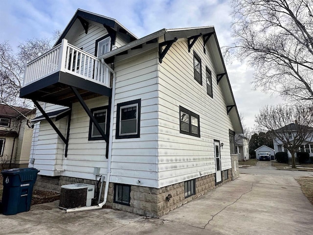 view of side of home featuring a balcony and central air condition unit