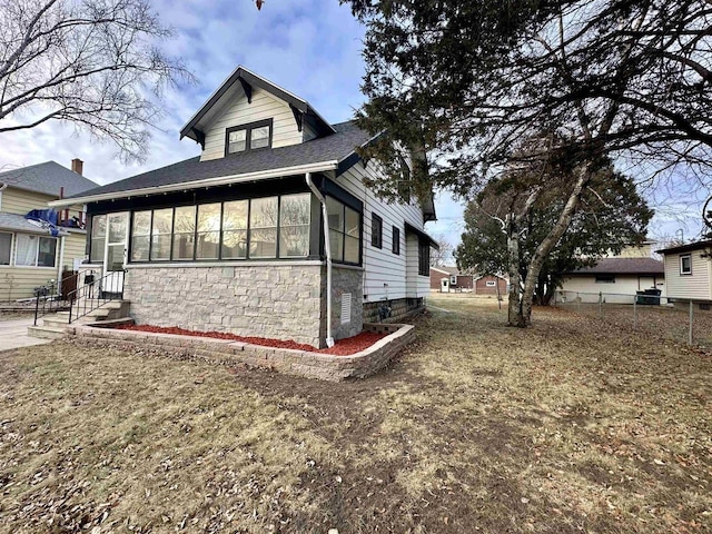 view of property exterior with a sunroom