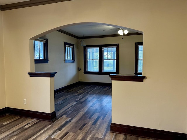 interior space with dark wood-type flooring, ceiling fan, and crown molding