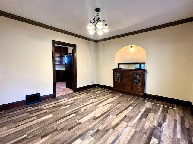 unfurnished room featuring ornamental molding, a chandelier, and hardwood / wood-style flooring