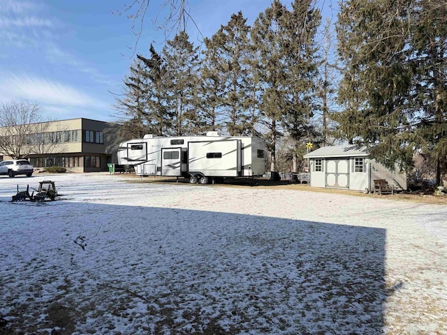 yard layered in snow with a storage shed