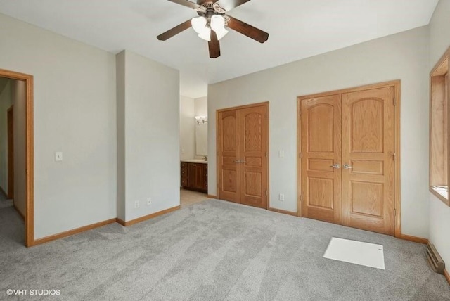 unfurnished bedroom with ceiling fan, connected bathroom, and light carpet