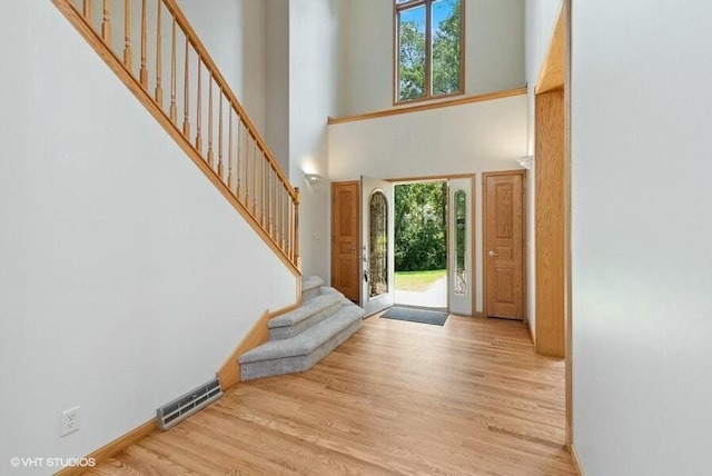 entrance foyer featuring plenty of natural light, light wood-type flooring, and a high ceiling