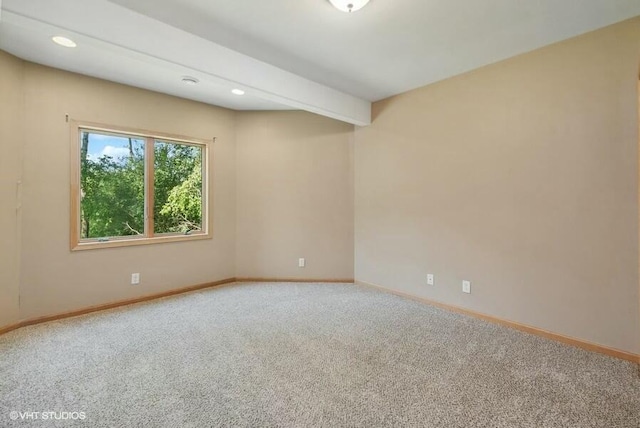 empty room with beamed ceiling and carpet