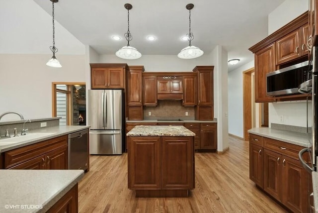 kitchen with sink, hanging light fixtures, a center island, and appliances with stainless steel finishes