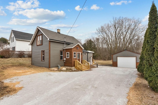 view of front of house featuring an outbuilding, a detached garage, and a chimney