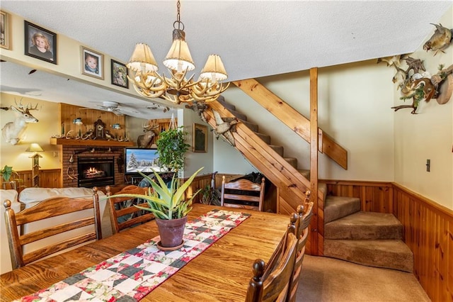 dining space featuring beam ceiling, a fireplace, and a chandelier