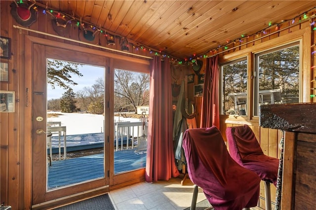 doorway to outside featuring wood walls and wooden ceiling