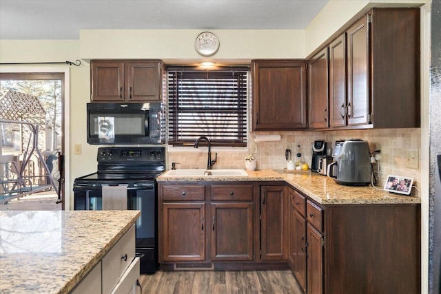 kitchen featuring backsplash, dark wood-type flooring, black appliances, sink, and light stone countertops