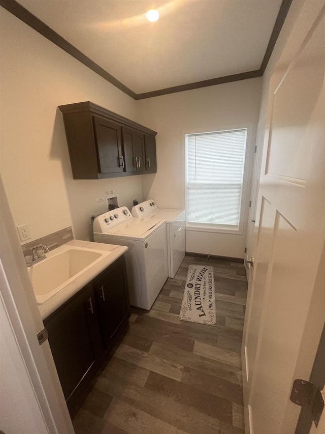 laundry area with cabinets, dark hardwood / wood-style flooring, ornamental molding, sink, and separate washer and dryer