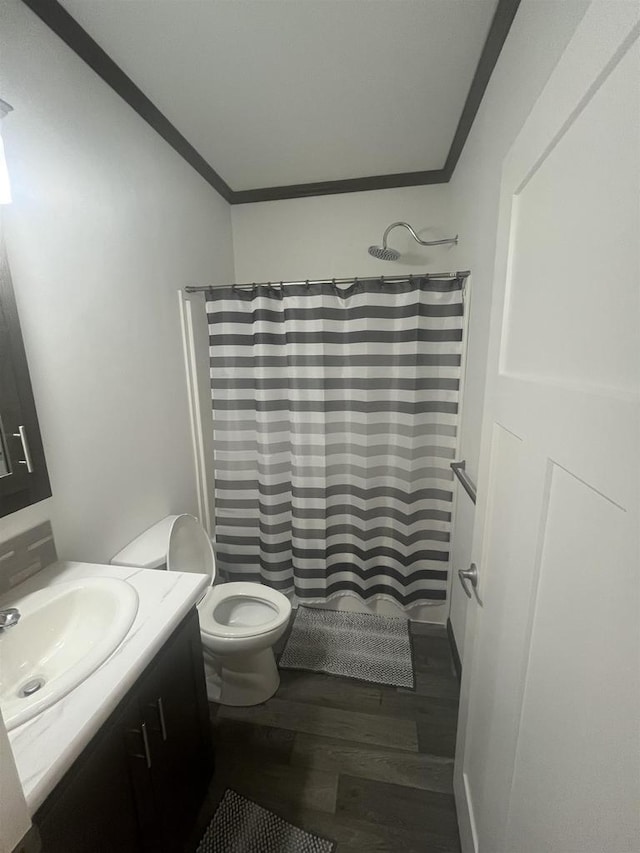 bathroom featuring a shower with shower curtain, vanity, hardwood / wood-style flooring, and ornamental molding