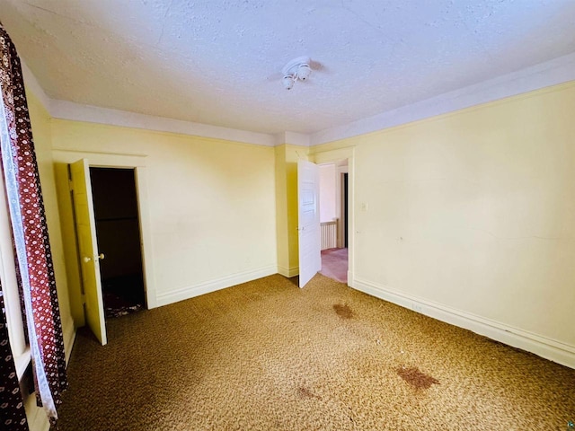 empty room with carpet flooring and a textured ceiling