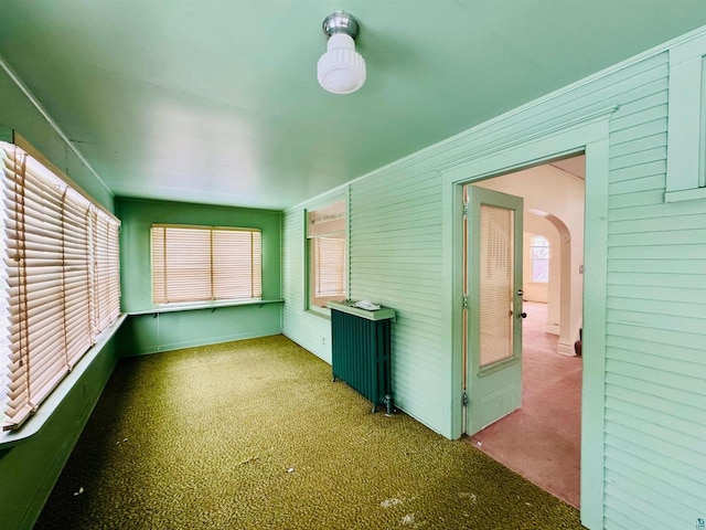 unfurnished sunroom with radiator and a healthy amount of sunlight