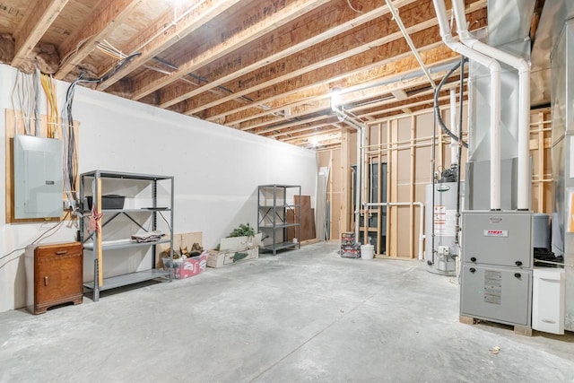 basement featuring electric panel and water heater