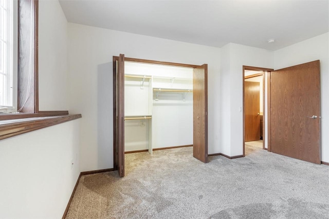 unfurnished bedroom with a closet and light carpet